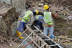 Group of construction workers fabricating ground beam formwork